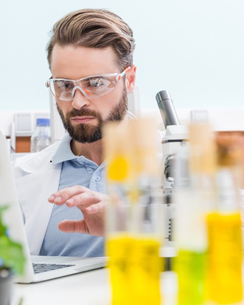 concentrated-bearded-scientist-working-with-laptop-QNW624C.jpg
